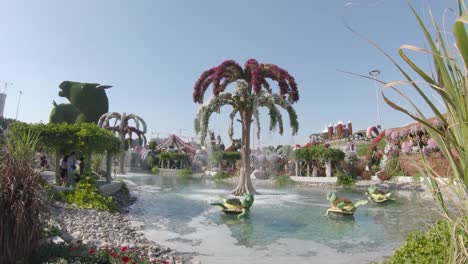 Palm-tree-flowery-fountain-in-pond,-Dubai-Miracle-Garden