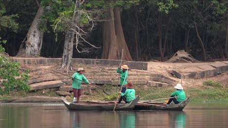 Plano-Medio-De-Damas-Asiáticas-En-Botes-Limpiando-El-Foso-Alrededor-De-Angkor-Wat-En-Camboya