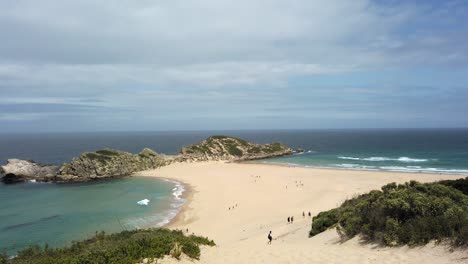 An-establishing-shot-of-the-Witsand-beach-of-the-Robberg-Reserve-reveals-a-white-sand-beach-bar-bridging-between-the-mainland-and-a-shelf-of-sharp-rocks-serves-as-the-perfect-location-for-tourists