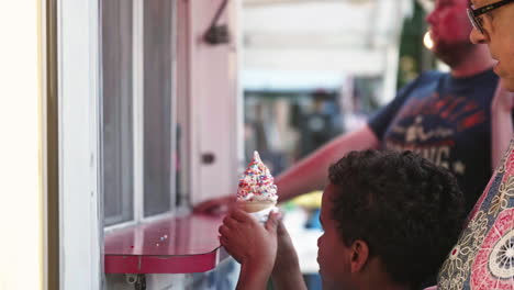 Little-boy-being-handed-ice-cream-cone-with-sprinkles-from-vendor,-Medium-Shot,-Slow-Motion