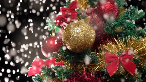Christmas-tree-decoration-detail-under-the-snow-in-winter-night-at-slow-motion