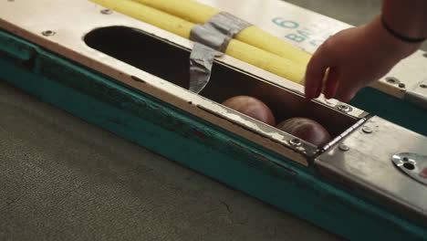 Mano-De-Mujer-Agarrando-Skeeball-En-Carnaval,-Cámara-Lenta