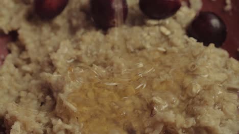 Runny-golden-honey-puring-over-porridge-with-cranberries-macro