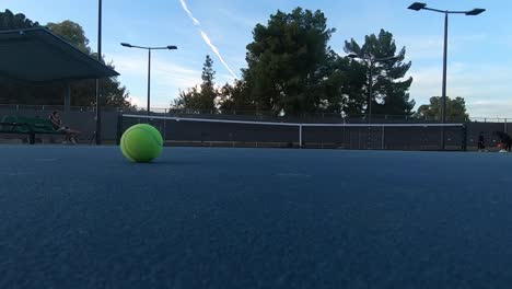 Primer-Plano-De-Una-Pelota-De-Tenis-Amarilla-Rodando-Hacia-La-Cancha-Publicitaria