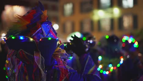 Close-up-shot-of-musician-playing-trumpet-in-illuminated-costume-during-carnival-festival-at-night