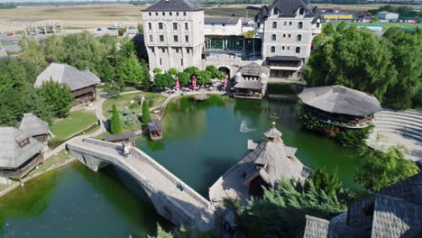 Cinematic-drone-shot-over-historic-castle-and-lake-at-Stanisici-ethnographic-village,-Bosnia