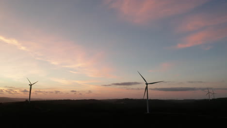 Turbinas-De-Energía-Eólica-Bajo-Un-Cielo-Sereno-Y-Colorido-Durante-La-Puesta-Del-Sol-En-Serra-De-Aire-E-Candeeiros,-Leiria-Portugal