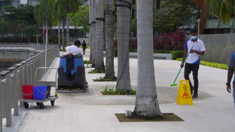 Small-machine-sweeper-cleans-the-pavement-on-the-promenade,-Singapore