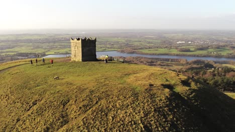 Hillside-summit-Rivington-tower-Lancashire-reservoir-vast-rural-countryside-aerial-orbit-left-view