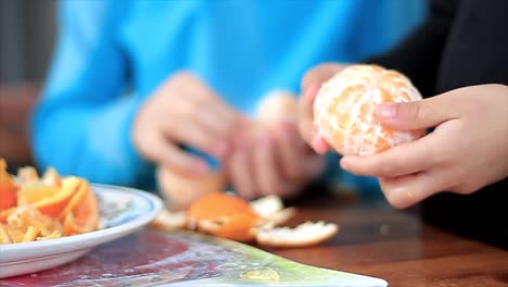 Niño-Pelando-Una-Fruta-De-Mandarina-Promoviendo-Una-Alimentación-Saludable-Almacen-De-Metraje-De-Video