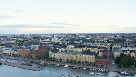 Slow-aerial-pan-of-buildings-along-the-Helsinki-waterfront-at-dusk,-Finland