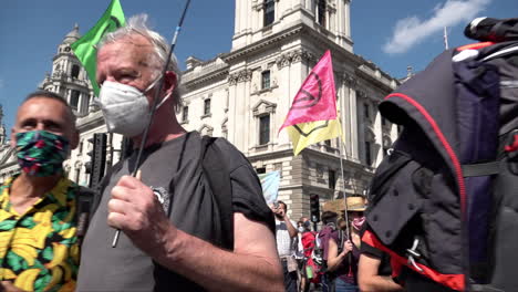 Los-Manifestantes-Del-Cambio-Climático-De-La-Rebelión-De-Extinción-Con-Máscaras-Protectoras-Debido-A-La-Pandemia-Del-Coronavirus-Con-Varios-Carteles-Y-Pancartas-Coloridos-Marchan-Por-Londres-En-Un-Día-Soleado