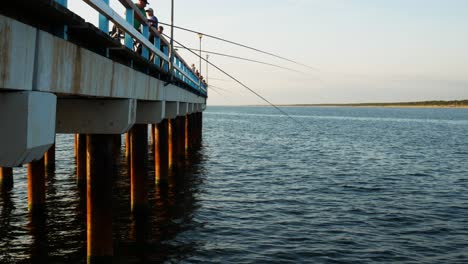 Fishermen-on-Palanga-bridge-waving-fishing-rods-to-cath-some-fish
