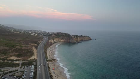 A-drone-glides-over-the-ocean-revealing-the-most-expensive-place-to-live-in-Orange-County-California-overlooking-crashing-ocean-waves