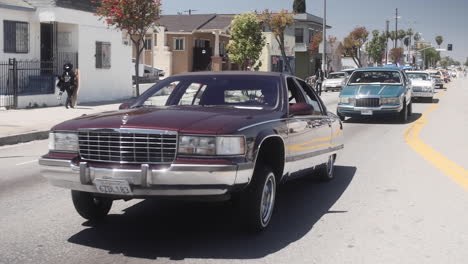 La-Car-Show,-Clásico-Cadillac-Brougham-Morado-Sobre-Rebote-Hidráulico,-Cámara-Lenta