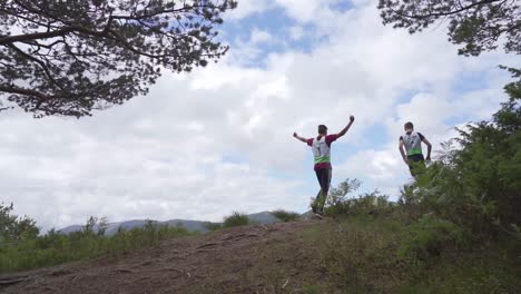 Slow-motion-Shot-runners-celebrate,-by-raising-arms-After-Climbing-peak-Mountain