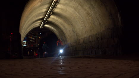 Los-Ciclistas-Recorren-El-Pasaje-Iluminado-Durante-La-Noche