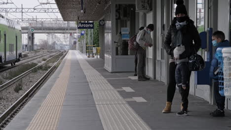 Una-Mujer-Con-Dos-Niños-Esperando-Un-Tren-En-La-Estación-Arcore