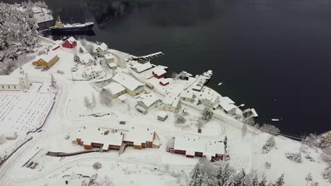 Small-remote-village-Stamnes-frozen-during-dark-and-long-winter-with-no-sun---Far-north-Aerial-shot-with-truck-passing-in-street