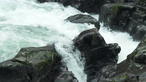 Water-splits-majestically-around-basalt-rocks-at-Moulton-Falls,-blue-hour,-static-shot