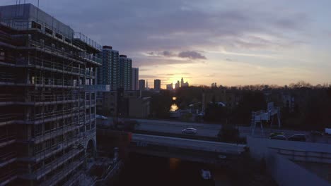 Establishing-Aerial-drone-dolly-forward-shot-of-London-Canal-towards-city-skyscrapers-at-sunset