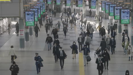 Slow-Motion-Of-Commuters-With-Face-Masks-Walking-At-The-Concourse-In-Shinagawa-Station-During-Pandemic---high-angle-shot