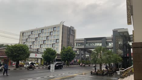 Yogyakarta-City,-Indonesia,-Static-View-of-Street-Traffic-in-Front-of-Ambarrukmo-Plaza-on-Rainy-Day