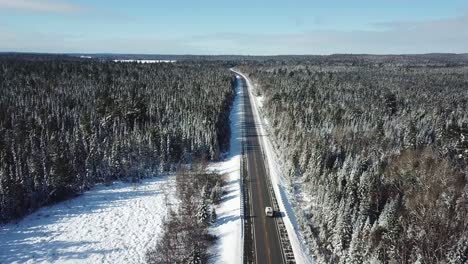 Cold-sunny-blue-sky-winter-day-in-the-northern-countryside-of-Canada---Drone-4k-Aerial-Van-driving