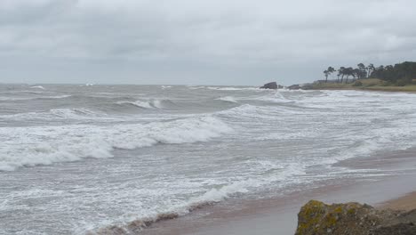 Waves-breaking-against-Baltic-sea-coastline-at-Liepaja,-stormy-overcast-autumn-day,-slow-motion-medium-shot
