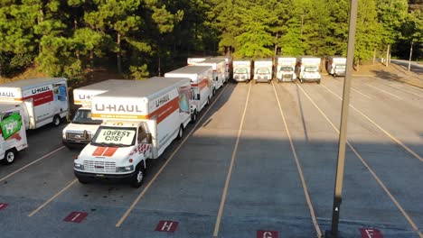 Una-Selección-De-Vehículos-En-Movimiento-Uhaul-Estacionados-En-Un-Lote-Al-Atardecer