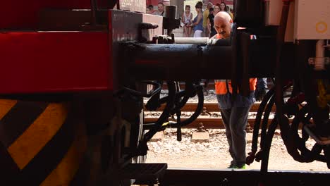 Die-Lokomotive-Wird-Mit-Dem-Rollmaterial-Verbunden,-Und-Ein-Bulgarischer-Eisenbahner-In-Orangefarbener-Warnschutzkleidung-Bewegt-Sich-Zwischen-Der-Lokomotive-Und-Den-Waggons,-Um-Sie-Miteinander-Zu-Verbinden