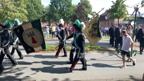 Hombres-Con-Sombreros,-Traje-Y-Bandera-Marchan-En-Dirección