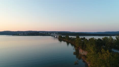 Aerial-birds-eye-view-over-a-lake-in-Missouri-flying-towards-a-bridge-parallel-with-a-highway