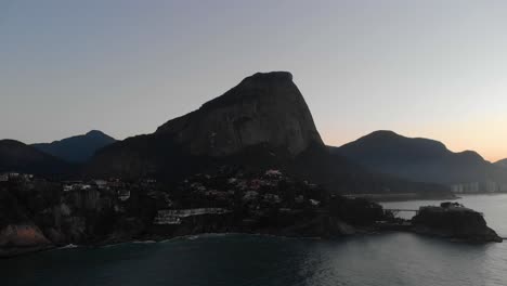 Aerial-approach-of-Joatinga-beach-with-the-Gavea-mountain-in-the-background-and-Costa-Brava-club-on-an-island-in-the-foreground-at-dawn-in-Rio-de-Janeiro