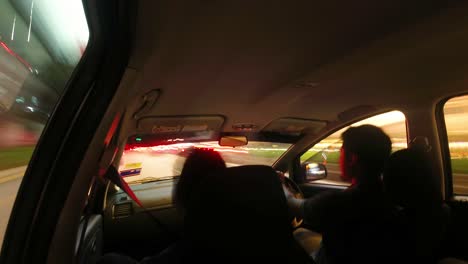 Backseat-view-of-car-speeding-on-highway-at-night