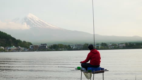 Weitwinkelaufnahme-Eines-Fischers,-Der-Einen-Fisch-Am-Kawaguchiko-See-Mit-Berg-Fängt