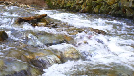 Blick-Auf-Den-Schnell-Fließenden-Fluss-Mit-Wasser,-Das-über-Felsen-Fließt,-Abgesperrt