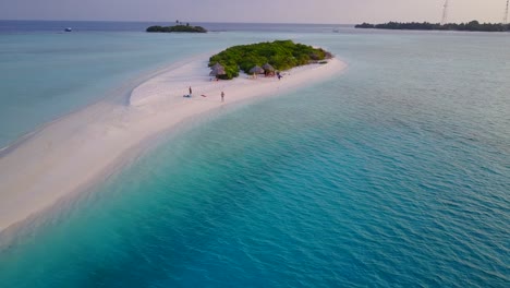 Paradiesische-Kleine-Tropische-Insel-Mit-Wunderschönem-Weißen-Sandstrand-Und-Türkisfarbener,-Ruhiger-Lagune,-Die-Von-Touristen-Besucht-Wird,-Die-Mit-Kajaks-Und-Booten-Auf-Die-Malediven-Kommen