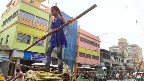 Poor-little-Asian-girl-walking-on-rope-in-India-with-stick-as-street-performer,-ultra-slow-motion