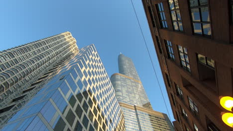 Torre-De-Triunfo-De-Chicago,-Rascacielos,-Edificios,-Vista-De-La-Ciudad,-Bandera-De-Estados-Unidos-Y-Chicago,-Automóviles-Y-Personas-Que-Pasan,-Movimiento-De-Cámara-Inclinable