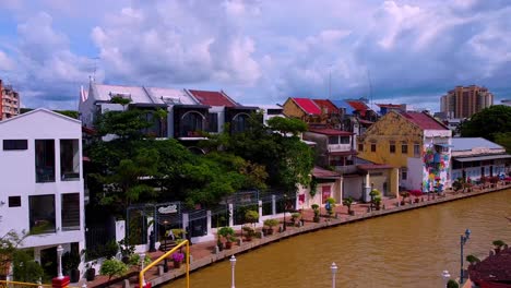 Aerial-flight-above-melaka-river-with-colorful-bridge-and-house-buildings,Asia