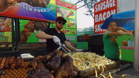 A-guy-stirs-carnival-fries-at-a-food-booth,-at-the-Orange-County-fair,-in-Costa-Mesa-California