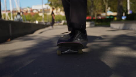Close-up-of-skateboard-on-concrete-walkway-and-skater-falling-off