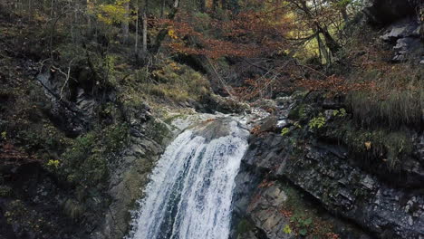 Drohne-Steigt-Im-Herbst-Vor-Einem-Wasserfall-In-Den-österreichischen-Alpen-Ab
