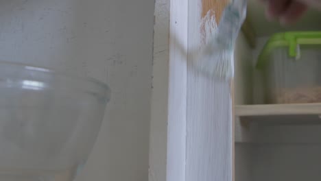 Eingesperrter-Mann-Bemalt-Eine-Holzkonstruktion-Mit-Pinsel-Weiß