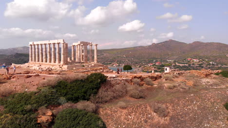 Greek-Temple-of-Poseidon-in-Athens-during-day,-descending-aerial-rotating-left