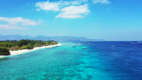 Paradise-tropical-island-with-pristine-white-sandy-beach-washed-by-blue-turquoise-water-of-calm-lagoon-under-bright-sky-with-white-clouds-in-Bali