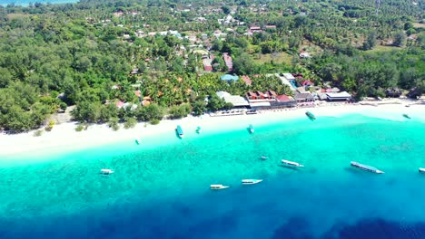 Idyllic-exotic-beach-with-white-sand-surrounded-by-azure-lagoon-full-of-anchored-boats-waiting-for-tourists-accommodated-in-resorts-of-tropical-island-in-Bali