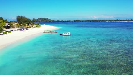 Boat-Slowly-Moving-Onto-The-Sandy-Shore-Of-The-Lush-Island-Surrounded-By-Bright-Blue-Sea-Water-With-Coral-Reef-At-The-Bottom---Wide-Shot
