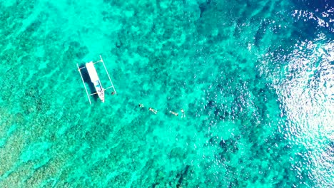 Fishing-Boats-Floating-By-The-Sea-With-Coral-Reefs,-Aneityum-Island,-Vanuatu---Aerial-Shot